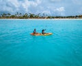 Couple Kayaking in the Ocean on Vacation Aruba Caribbean sea, man and woman mid age kayak in ocean blue clrea water