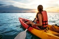 Couple kayaking together. Beautiful young couple kayaking on lake together and smiling at sunset