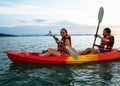 Couple kayaking together. Beautiful young couple kayaking on lake together and smiling at sunset