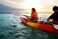 Couple kayaking together. Beautiful young couple kayaking on lake together and smiling at sunset Royalty Free Stock Photo