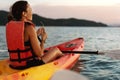 Couple kayaking together. Beautiful young couple kayaking on lake together and smiling at sunset Royalty Free Stock Photo