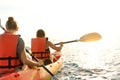 Couple kayaking together. Beautiful young couple kayaking on lake together and smiling at sunset Royalty Free Stock Photo