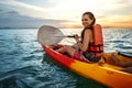 Couple kayaking together. Beautiful young couple kayaking on lake together and smiling at sunset Royalty Free Stock Photo