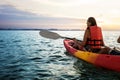 Couple kayaking together. Beautiful young couple kayaking on lake together and smiling at sunset Royalty Free Stock Photo