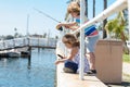 Couple of kids fishing on pier. Child at jetty with rod. Boy and girl with fish-rod. Royalty Free Stock Photo