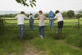 Couple With Kids Looking At Lush Landscape By Fence