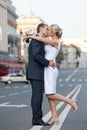 Couple in a kiss on the road. Newlyweds kissing on the dividing strip. Wedding theme.