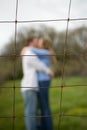 Couple kissing behind a fence