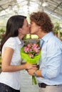 Couple kissing in flower nursery Royalty Free Stock Photo