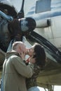 Couple kissing in front of propeller of old plane on sunny day. Couple in love full of desire hugs near airplane on