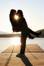 A couple kissing on a jetty by the water at sunset Royalty Free Stock Photo