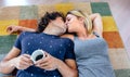 Couple kissing lying on the carpet