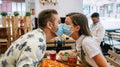 Couple kissing with mask sitting in a restaurant Royalty Free Stock Photo