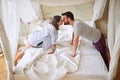 Couple kissing in the morning while making the bed. bedroom, morning,  togetherness, concept Royalty Free Stock Photo