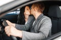 Couple kissing in new car, showroom Royalty Free Stock Photo