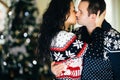 Couple kissing next to christmas tree