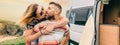 Couple kissing piggybacking next to their camper van during a trip Royalty Free Stock Photo