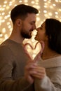 couple kissing and showing the heart-shaped figure of candy canes candies