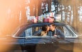 Couple kissing in vintage car with presents on roof