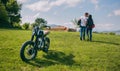 Couple kissing and walking on the field with motorbike Royalty Free Stock Photo