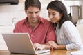 Couple in kitchen with laptop smiling Royalty Free Stock Photo