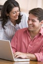 Couple in kitchen using laptop smiling Royalty Free Stock Photo