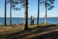 A couple on the lake, at sunset, in a pine forest. Royalty Free Stock Photo