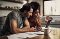 Couple with a laptop doing finance paper work, paying debt insurance loans or online ebanking together at home. Two Royalty Free Stock Photo