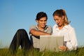 Couple with laptop on meadow Royalty Free Stock Photo