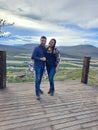 Couple of Latin adult man and woman enjoy the mountainous view of vineyards from a viewpoint you can see the land planted with vin