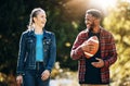 Couple laughing, American football in park and happy together in nature, walking outdoor and sports in the sun
