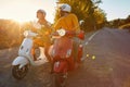 Couple laughing and riding on a scooter in European on vacation