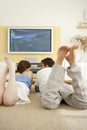Couple Laying Down on Floor Watching TV Royalty Free Stock Photo