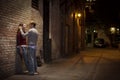 Couple leaning against brick wall in alley way