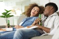 couple leaning back on sofa holding beers and pizza Royalty Free Stock Photo