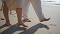 Couple legs stepping sand beach leaving footprints closeup. Pair tourist walking