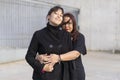 Couple of lesbian women hugging in a park looking at the camera.