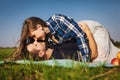Couple lie on the grass. girl top of the guy. She kisses him Royalty Free Stock Photo