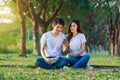 Couple listening music from mobile with headphone in the park Royalty Free Stock Photo