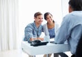 Couple listening to financial advisor. Portrait of young couple listening to financial advisor in office. Royalty Free Stock Photo