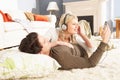 Couple Listening To MP3 Player Laying On Rug