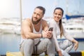 Couple listening to music together using one earphones sitting on pier Royalty Free Stock Photo