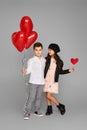 Couple of little girl and boy with red heart balloons Royalty Free Stock Photo