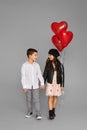 couple of little girl and boy with red heart balloons Royalty Free Stock Photo