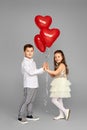 couple of little girl and boy with red heart balloons Royalty Free Stock Photo