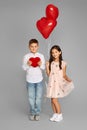 Couple of little girl and boy with red heart balloons Royalty Free Stock Photo