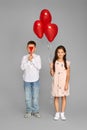 couple of little girl and boy with red heart balloons Royalty Free Stock Photo