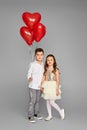 couple of little girl and boy with red heart balloons Royalty Free Stock Photo