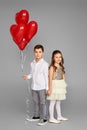 couple of little girl and boy with red heart balloons Royalty Free Stock Photo