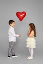 couple of little girl and boy with red heart balloons Royalty Free Stock Photo